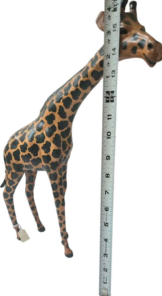 Giraffe toy with a measuring tape next to it on a white background